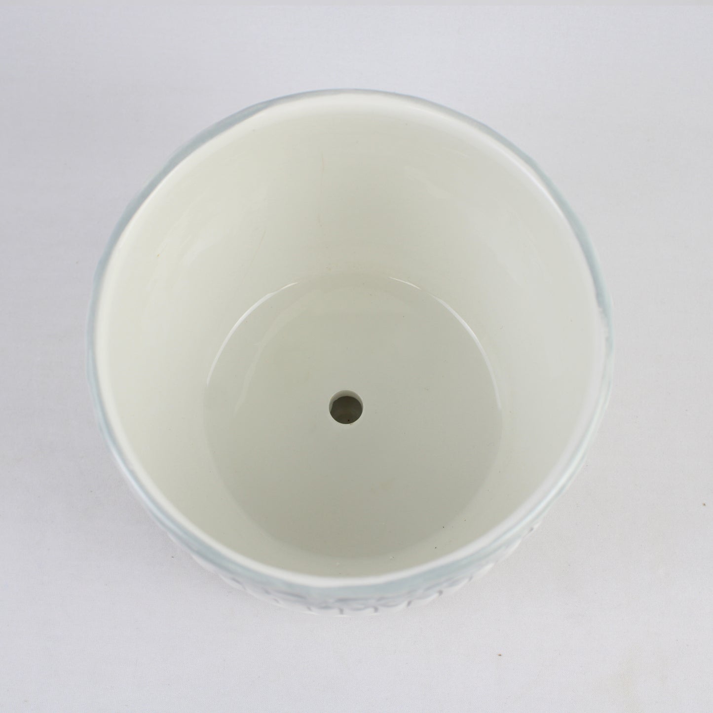 White plastic cup with a central hole on a white background