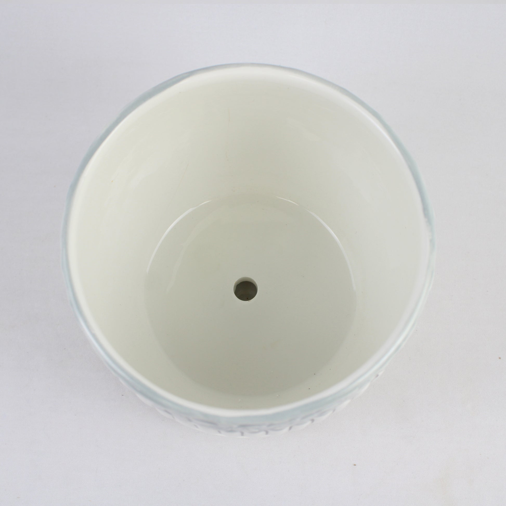 White plastic cup with a central hole on a white background