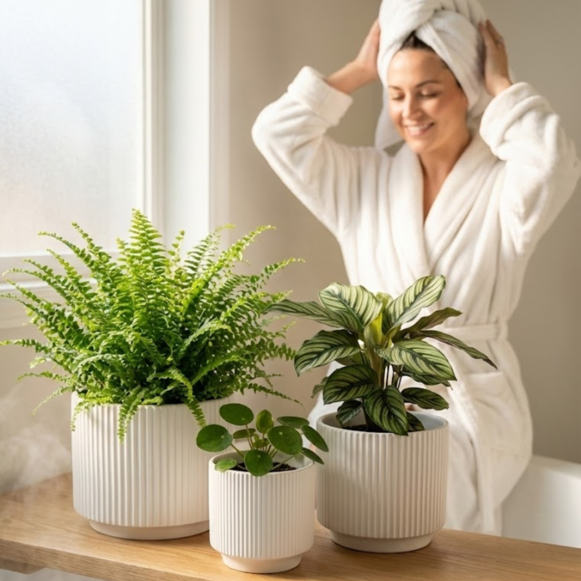 Woman in a white robe with plants on a table